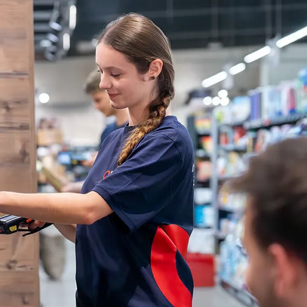 Mitarbeiterin führt mit einem Scanner eine Inventur in einem Supermarkt durch