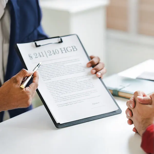 Person zeigt auf ein Dokument mit Paragraphenzeichen – Symbolbild für Rechtssicherheit und gesetzeskonforme permanente Inventur nach § 240 Abs. 1 HGB.