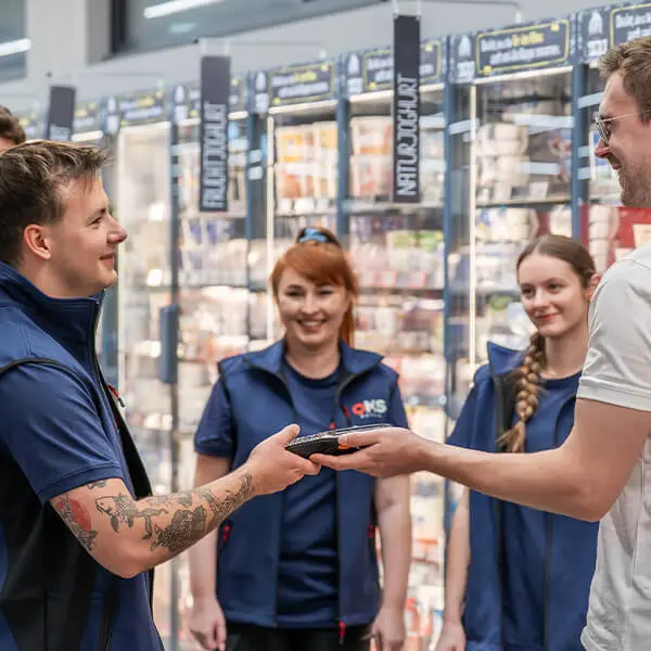 OMS Retail Mitarbeitende führen eine Inventur im Einzelhandel durch und übergeben ein mobiles Erfassungsgerät