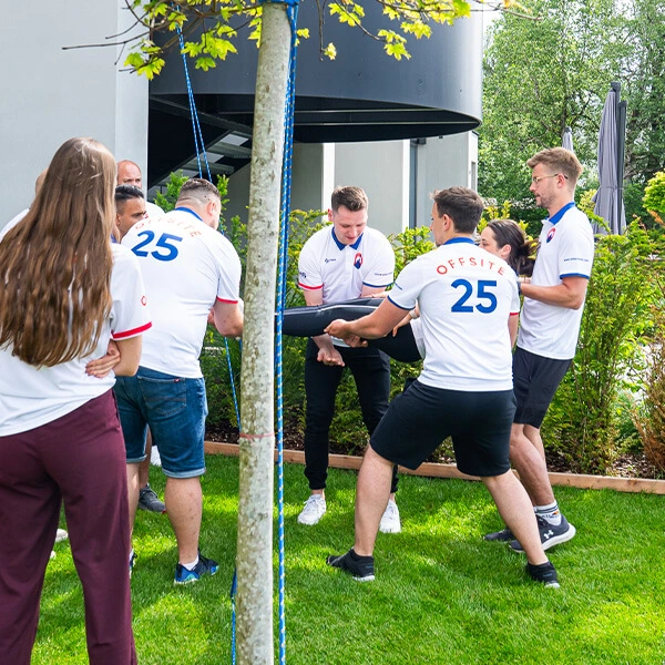 Teammitglieder bei einer Outdoor-Übung – gemeinsames Lösen einer Aufgabe im Rahmen eines Teamtrainings.