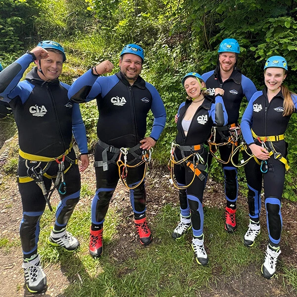 Team in Kletterausrüstung bei einer Outdoor-Abenteueraktivität – gemeinsamer Spaß und Teamgeist in der Natur.