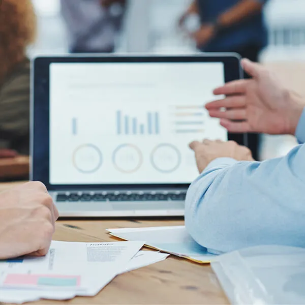 Zwei Geschäftsleute besprechen ein Inventurverfahren in einem modernen Grossraumbüro.