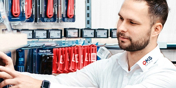 Techniker führt Batteriewechsel an elektronischen Preisschildern im Geschäft durch